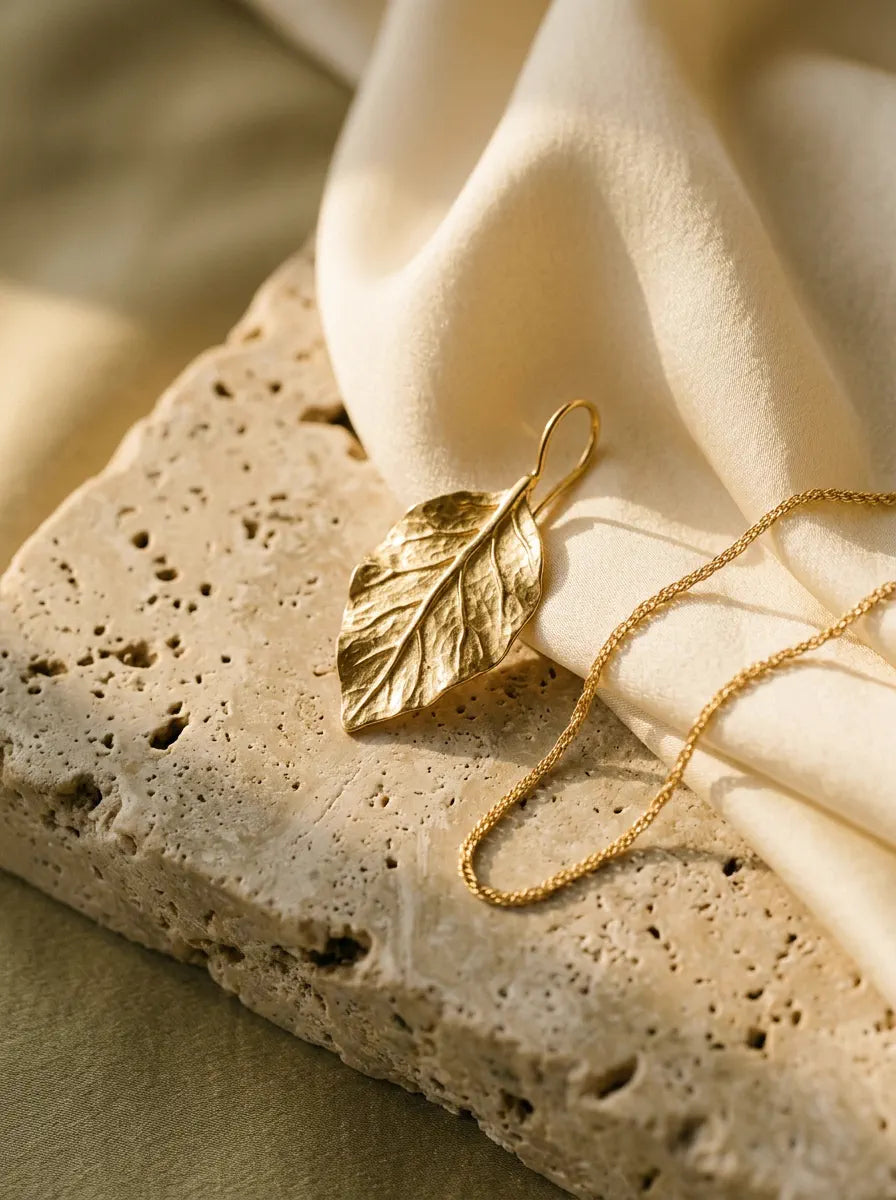 Avirena golden botanical leaf jewel on travertine stone